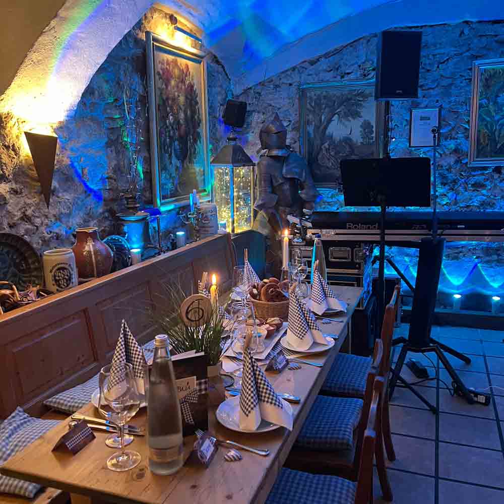 Stilvoll gedeckter Tisch im Wirtshaus Zur Wurz’n in Vilshofen mit Live-Musik Setup und stimmungsvoller Beleuchtung