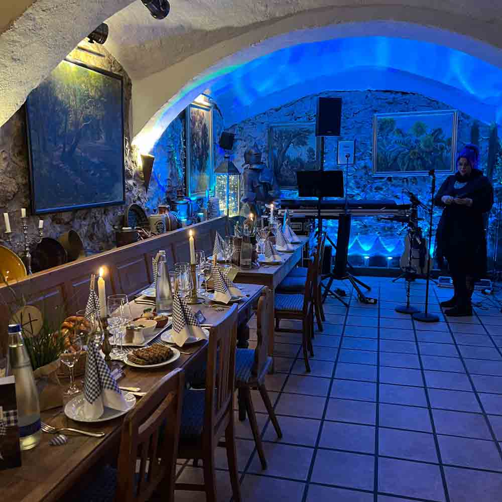 Gastraum im Wirtshaus Zur Wurz’n in Vilshofen mit gedeckten Tischen, Live-Musik Bereich und stimmungsvoller Beleuchtung